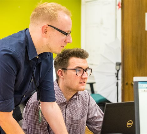 2 men looking at computer