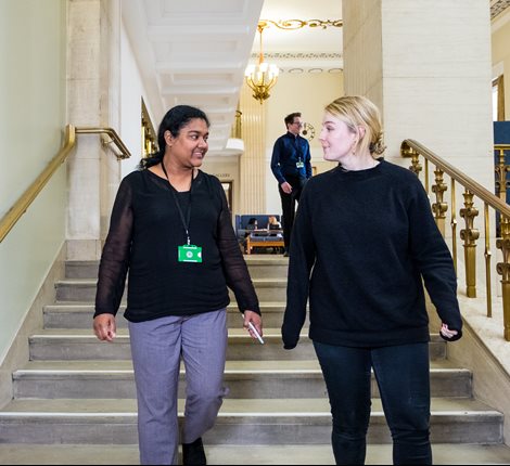 2 women walking down stairs talking smiling