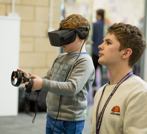 Volunteer helping boy with a VR headset