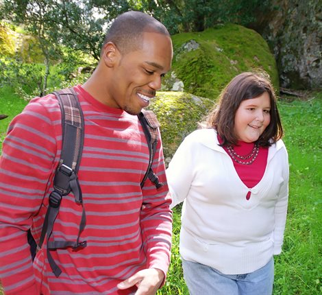 Man and woman walking through a park
