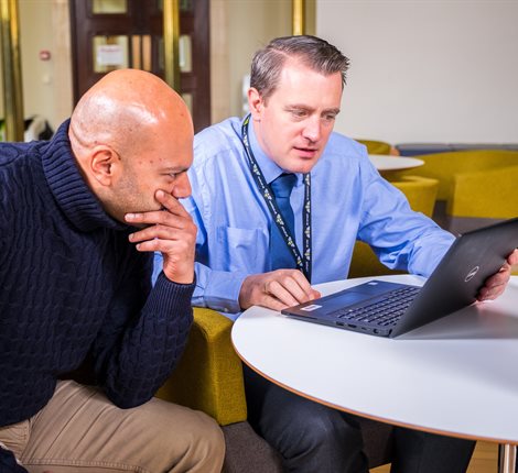 men looking at a laptop