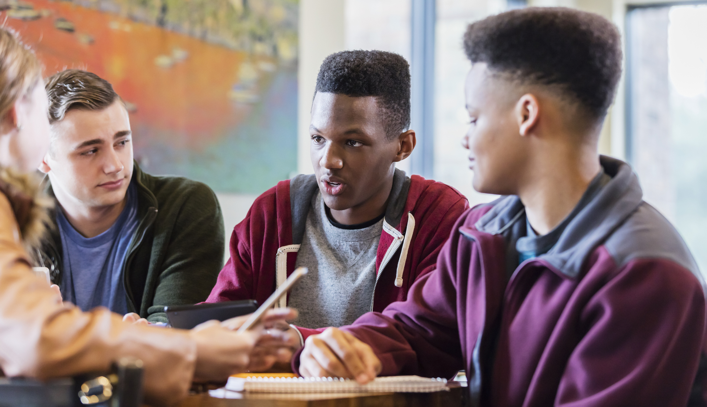 Group of young people talking at a table