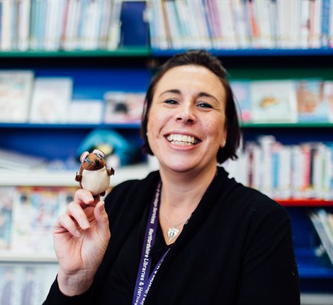 Librarian smiling with a finger puppet