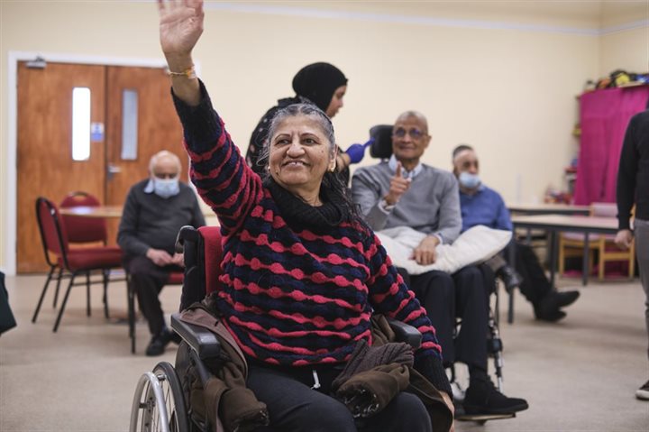 Woman in a wheelchair waving