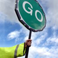 Person in hi-vis with a go sign